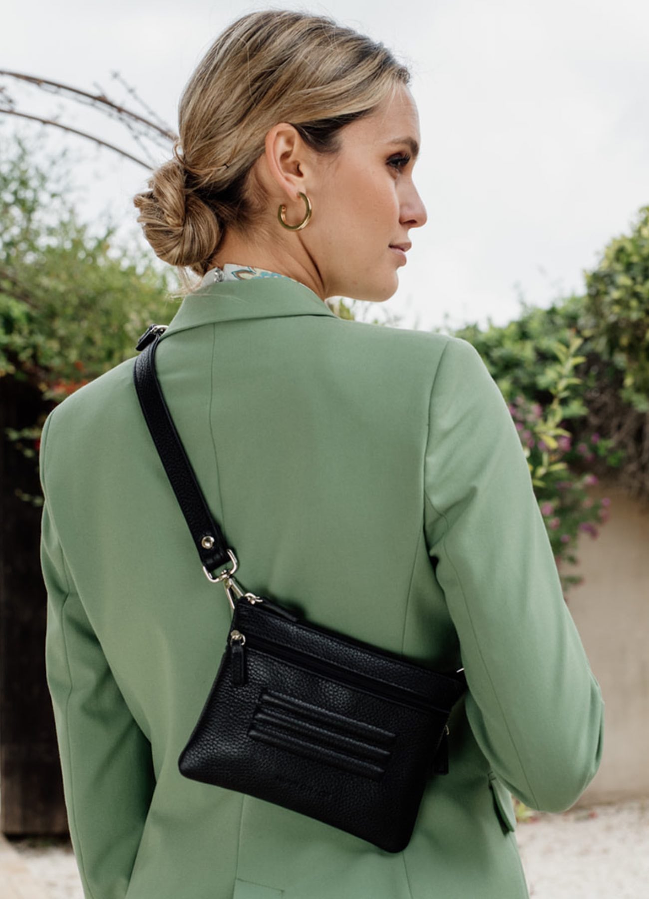 [wv] Hippi Grace Cadizfornia er en Liten veske  til dame i ekte skinn, crossbody skulderstropp, håndeddstropp,utvendig glidelås-lomme foran og bak, glidelås lukking, sølvdetaljer. Hippi Grace Cadizfornia i fargen klassisk sort med søllv detaljer. Sort veske. Svart Veske. Veske Dame. Norsk Design. Liten Crossbody veske dame. Vesken har et praktisk interiør og har glidelås lukking i topp.  Bilde av model bakfra for å vise ekte størrelse på vesken. 