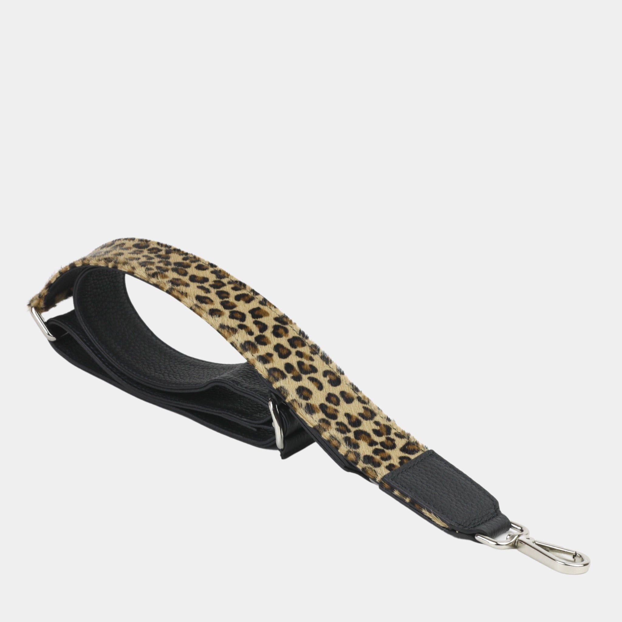 Bred skulderstropp i klassisk Ku-skinn, Crossbody lengde, Preget Logo, sølv detaljer. Hippi Grace Preget Regulerbar Stropp i Klassisk Sort med Leo Print. Ekte skinn. Skinnstropp til veske i ekte skinn. Norsk Design.