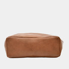 Lysebrun tote bag i ku-skinn. Tote veske i lekkert lyse brunt skinn fra Hippi Grace. Tote vesken Stockholm i fargen bohem luxe tan grain fra Hippi Grace er en stor skinnveske til dame. Skulder vesken passer perfekt som jobbveske, skoleveske, reiseveske og hverdagsveske. Vesken har et stilrent design, med et romslig interiør. Vesken lukkes med en metallknapp i topp. Skinnveske dame. Lysebrun tote bag i ekte skinn. Lysebrun skulderveske i ekte skinn. Norsk design. Undersiden av vesken. [wv]